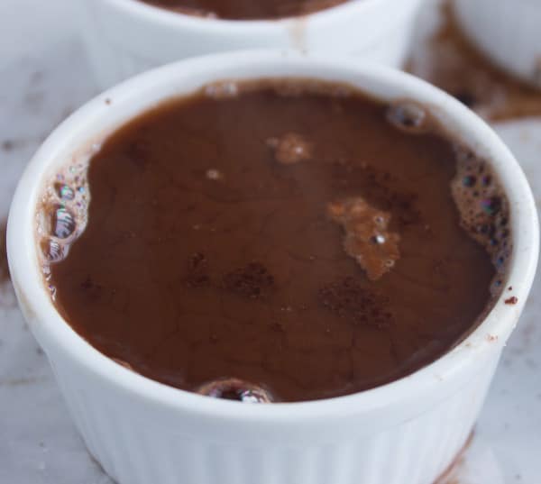 boiling water being poured over chocolate mixture to make pudding cakes