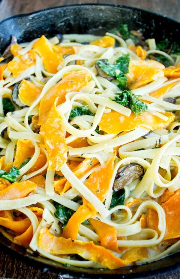 Overhead shot of Healthy Kale Squash Mushroom Pasta in a creamy sauce served in a black skillet