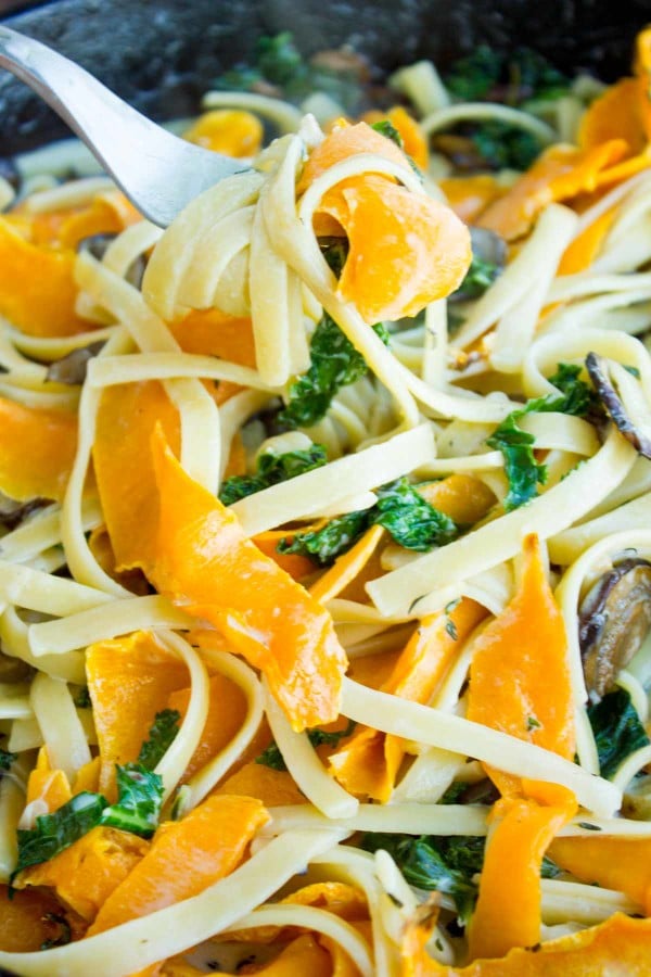 Overhead shot of Healthy Kale Squash Mushroom Pasta in a creamy sauce served in a black skillet
