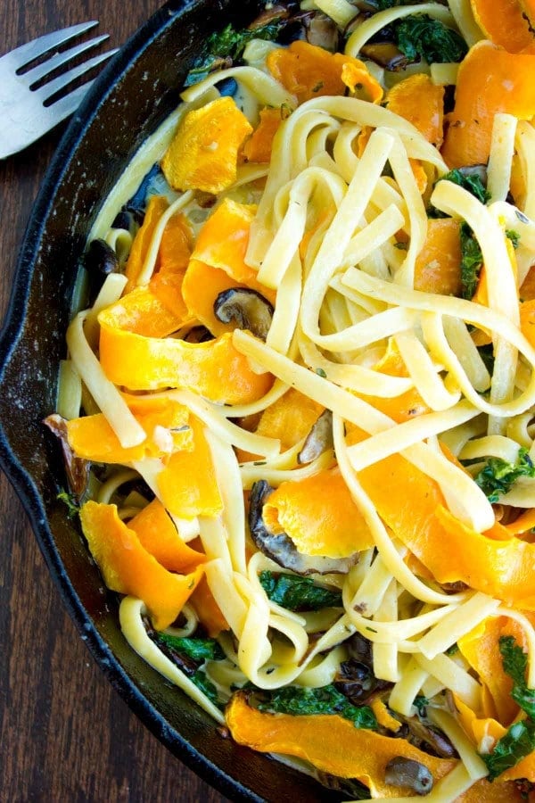 Overhead shot of Healthy Kale Squash Mushroom Pasta in a creamy sauce served in a black skillet