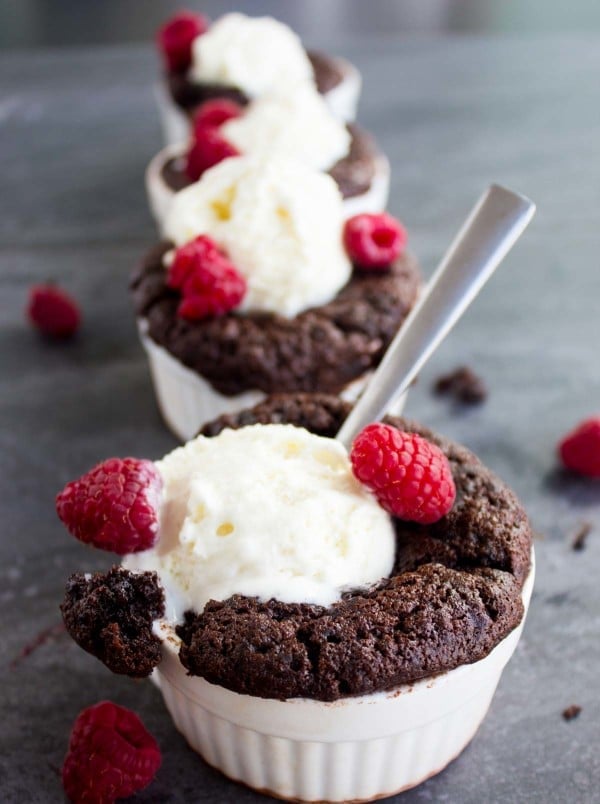 Mini Chocolate Pudding Cakes in individual ramekins served with ice cream and fresh raspberries on top