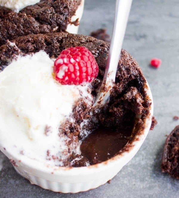 half eating Mini Chocolate Pudding Cake with some melted ice cream and a raspberry on top