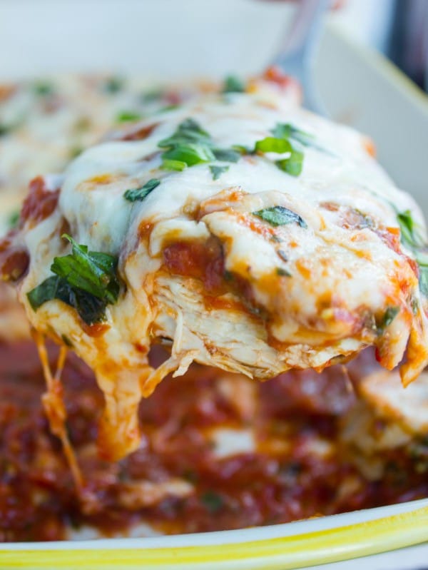 Grilled Chicken Parmesan right out of the oven, close up held up above the plate.