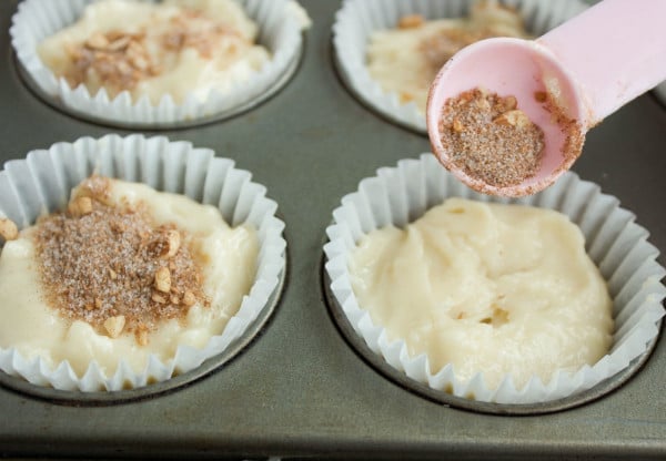 unbaked cinnamon rolls muffins being sprinkled with cinnamon sugar