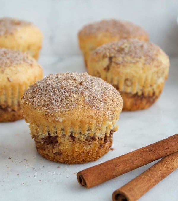 side view of cinnamon roll muffins on a white tabletop 