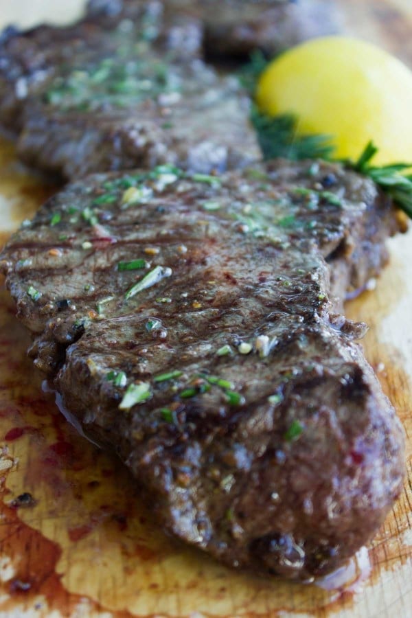 perfectly Grilled Steak with Rosemary Lemon Butter served on a cutting board