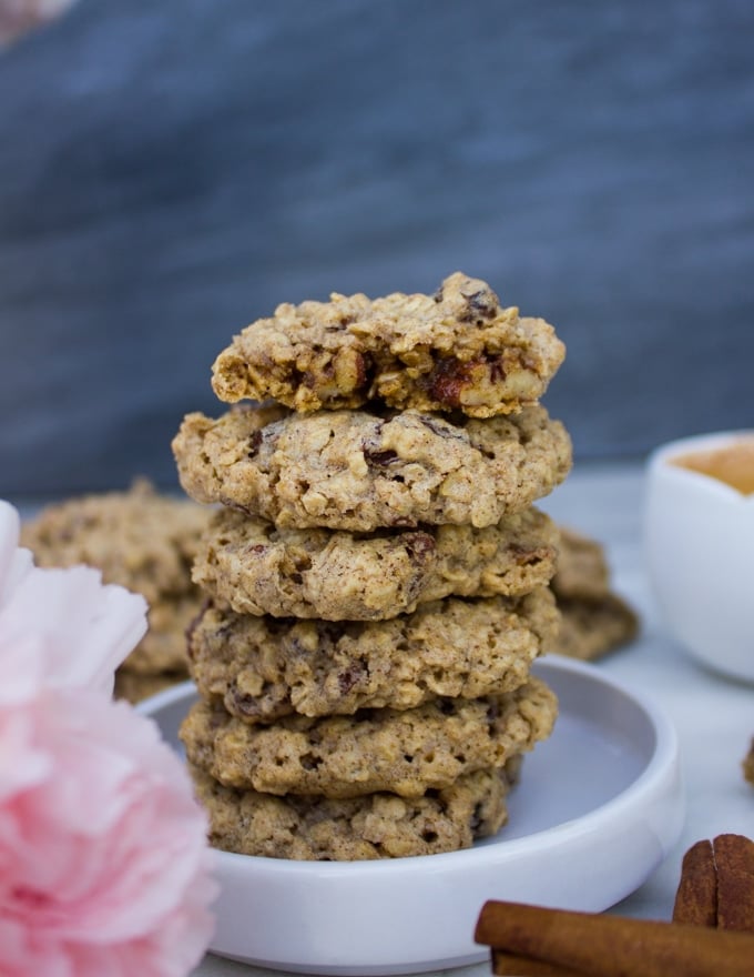 stacks of healthy oatmeal cookies wwith one bitten cookie on the top showing the texture of the cookies on the inside