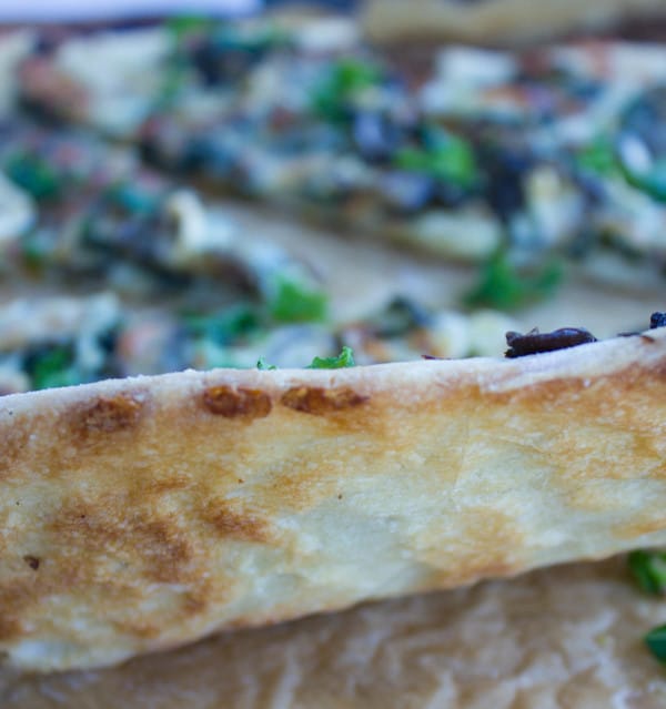 zoom in on the perfect pizza crust of a kale mushroom brie pizza