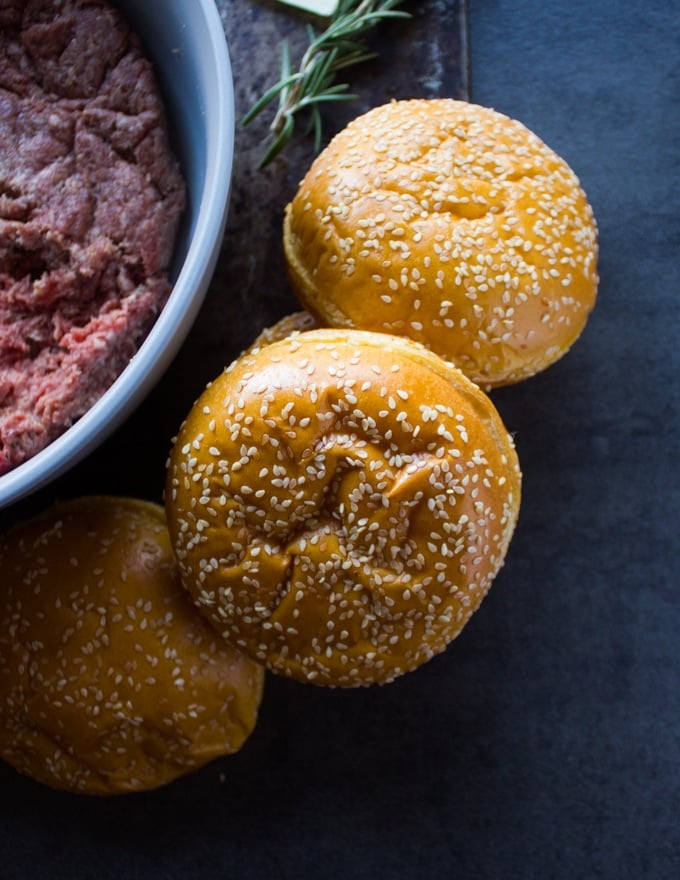 Brioche buns on a board with sesame topping