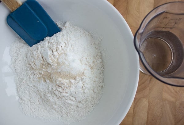 dry ingredients for overnight pizza dough in a white bowl