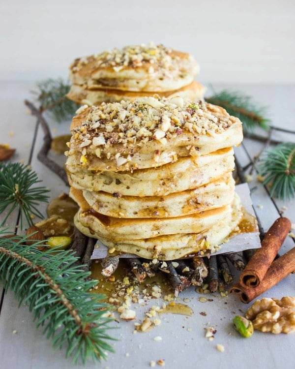 a stack of Baklava Pancakes topped with chopped nuts and drizzled with Maple Syrup