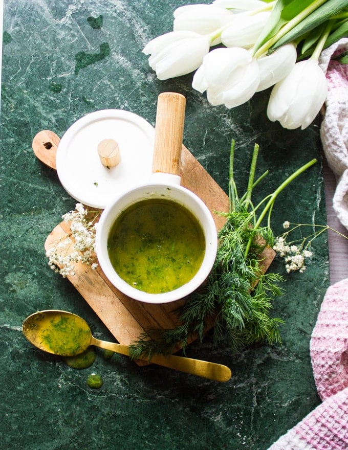 A bowl with the sauce ready and some white tulips around it 