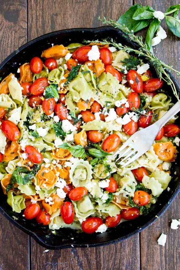 overhead shot of 10 Minute Greek Feta Cheese Tortellini in a black skillet with a fork in the skillet