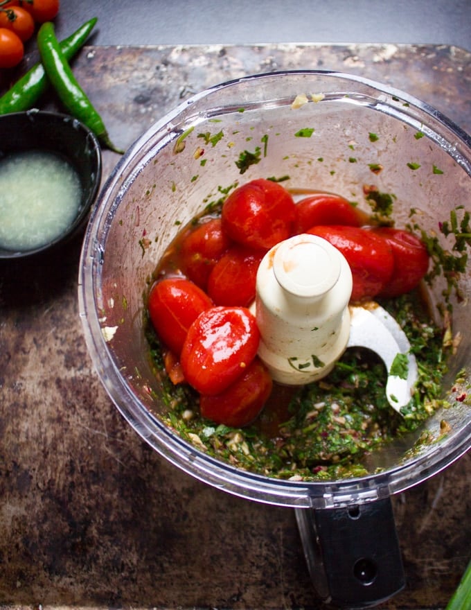 tomatoes in a food processor ready to be pulsed