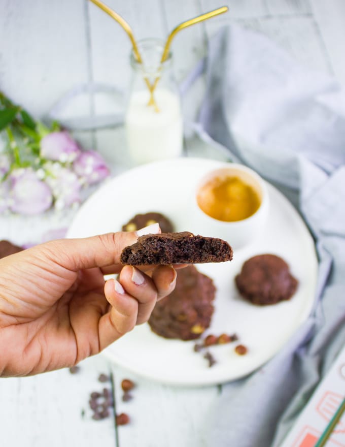 A hand holding a bitten off brownie cookie to show the soft insides