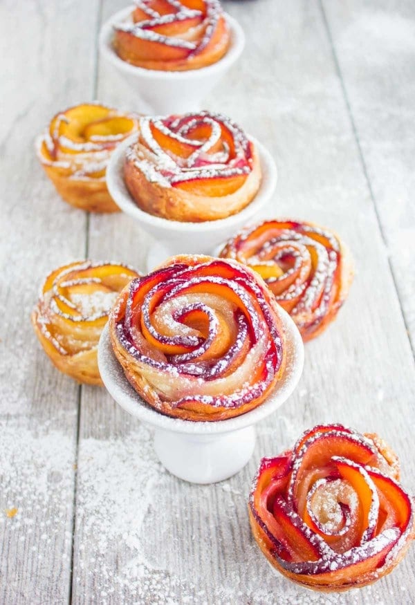 individual sugar-dusted Peach Plum Rose Tarts served on small cake stands