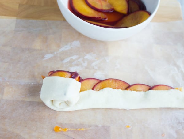 pastry topped with jam and stone fruits rolled up to make rose tarts