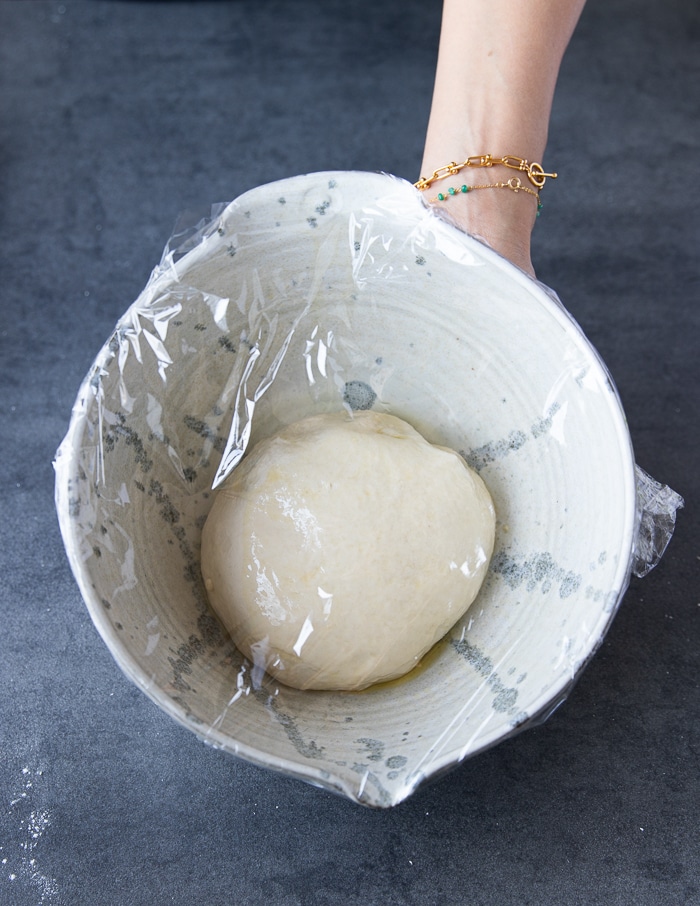 The pizza dough recipe covered in a bowl and has to rise