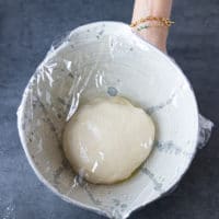 pizza dough in a bowl, covered and rising,.