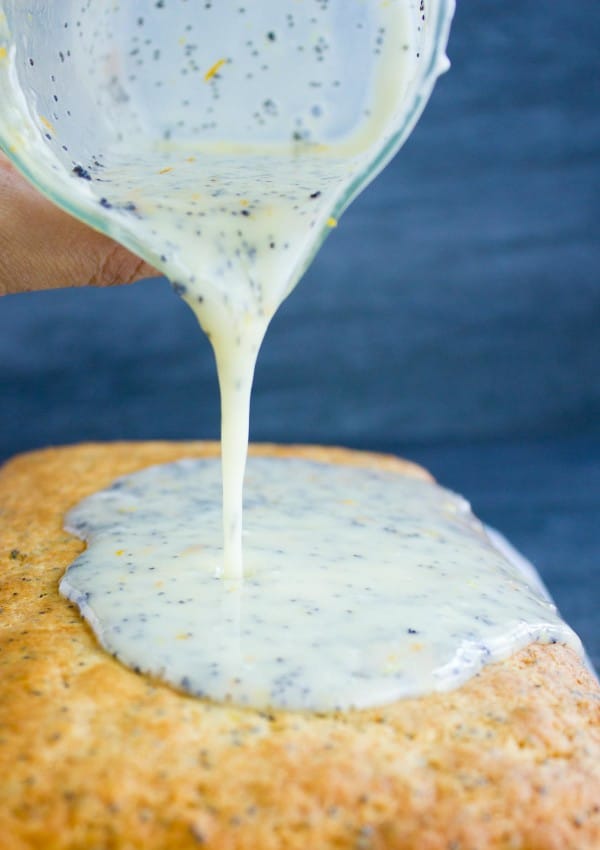 Greek Yoghurt Glaze being poured on top of a Citrus Poppy Seed Loaf cake