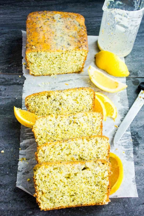 Citrus Poppy Seed Loaf with Yogurt Glaze on a piece of parchment paper, sliced and ready to be served