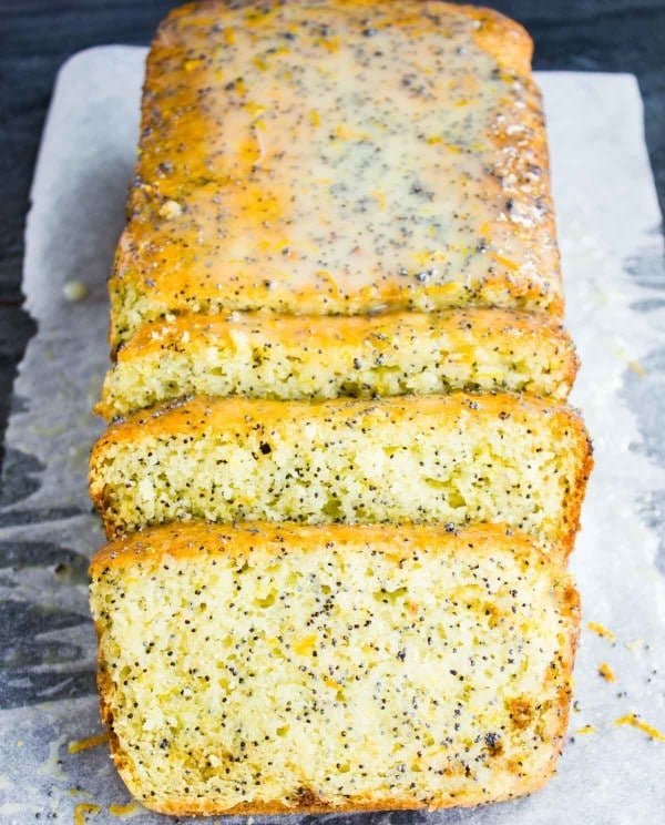 a sliced loaf of moist Citrus Poppy Seed Loaf with glistening Yogurt Glaze on top.