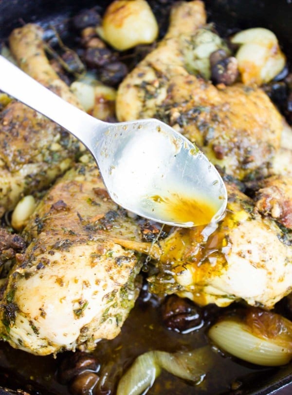 gravy being drizzled on top of Garlic Herb Roast Chicken in a black skillet