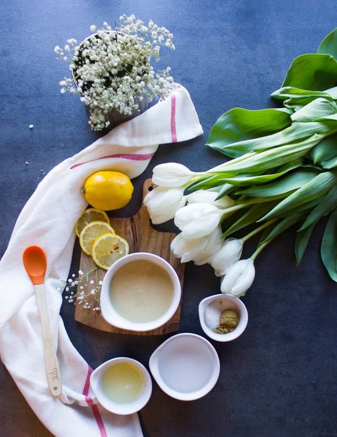 Ingredients for the tahini sauce, a bowl of tahini paste, lemon juice, a bowl of water, a bowl with salt and cumin