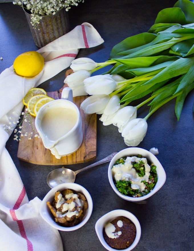 The tahini sauce showing how to use it such as poured over shawarma, poured over tabouleh, and poured over falafel. 