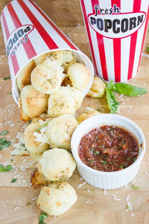 Pizza Popcorn Bites rolling out of a tipped over read and white popcorn box