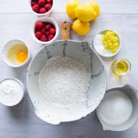 ingredients for the raspberry muffins recipe including flour, baking powder, sugar, lemon zest, oil, egg, yogurt, raspberries