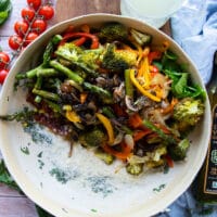 Tossing the roasted veggies with the sauce ingredients in a large bowl.