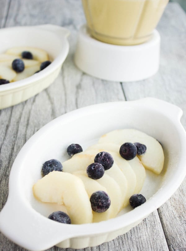 sliced pears and blueberries arranged in a small ramekin