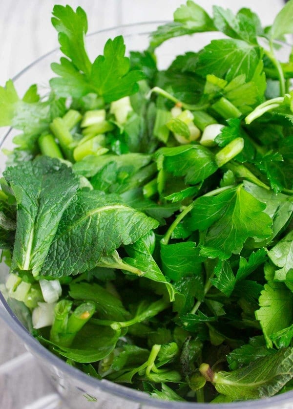 fresh herbs and scallions in a food processor before chopping them into tabouleh