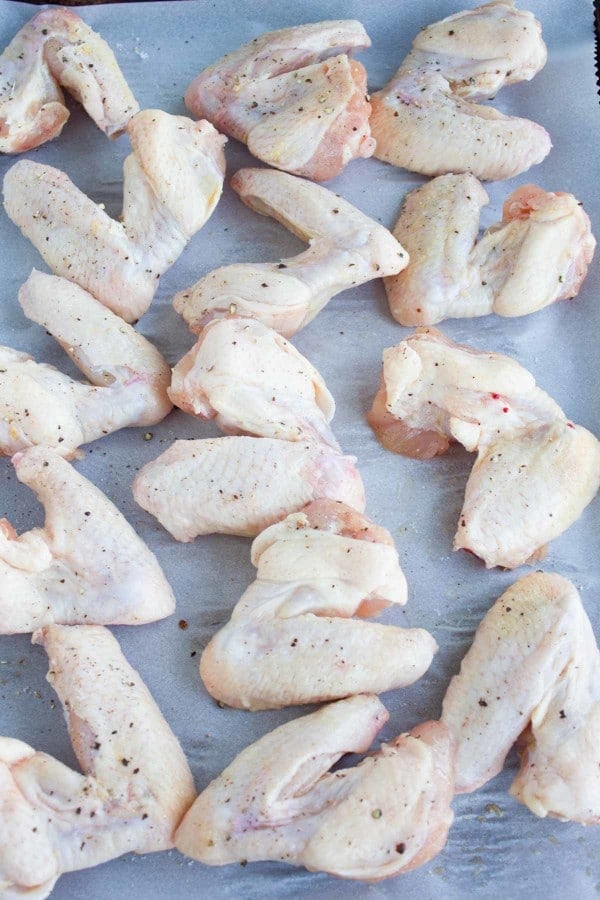 raw chicken wings arranged on a baking tray