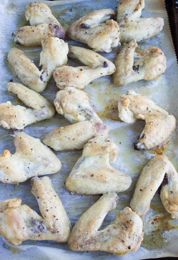 pre-baked chicken wings arranged on a baking tray