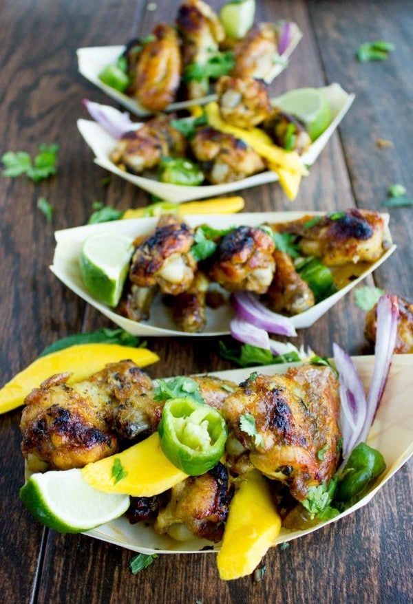 Sweet and Spicy Chicken Wings smothered in Mango Chutney and served in small paper boats with some fresh cilantro and mango slices