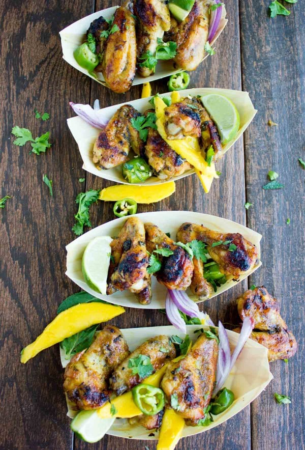 Sweet and Spicy Chicken Wings smothered in Mango Chutney and served in small paper boats with some fresh cilantro and mango slices
