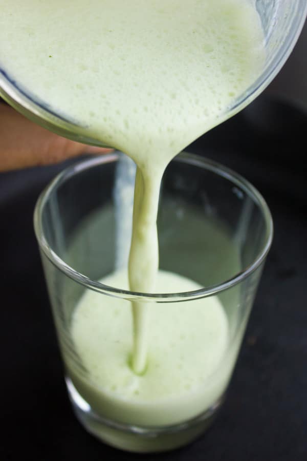 Turkish Ayran drink being poured into a tall glass