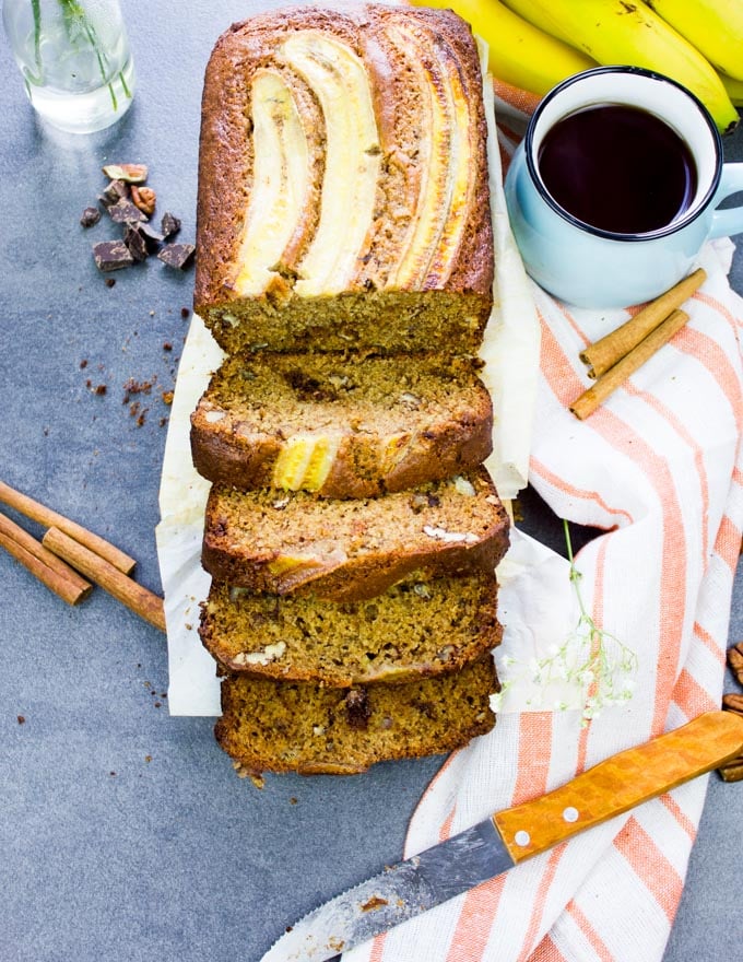 Whole Wheat Banana bread loaf sliced up and surrounded by cinnamon sticks