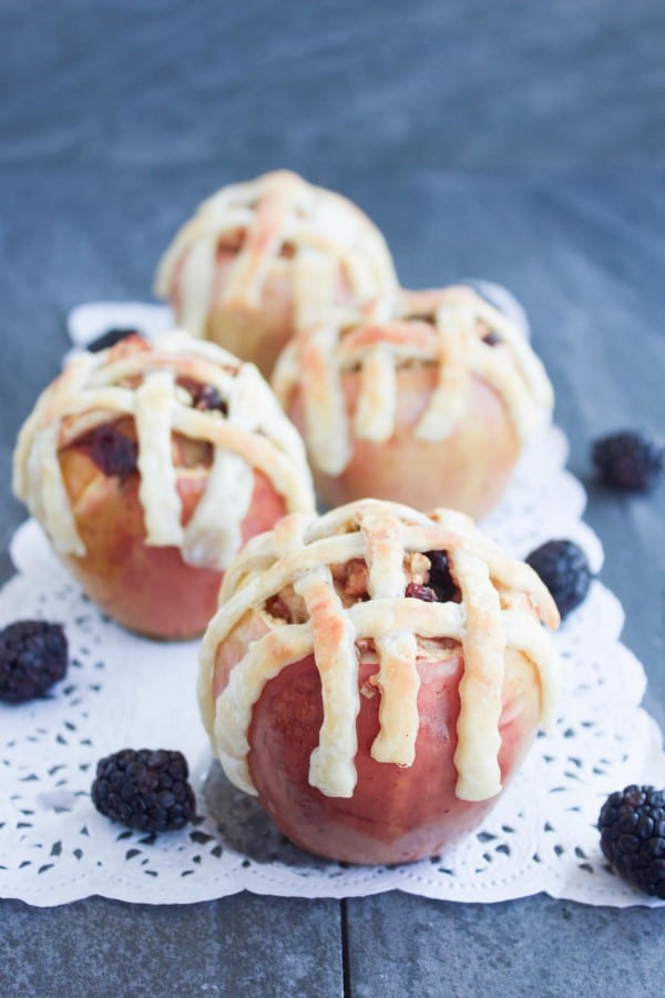 Apple Pie Stuffed Apples with golden brown pie crust lattice on top served on a cake doily