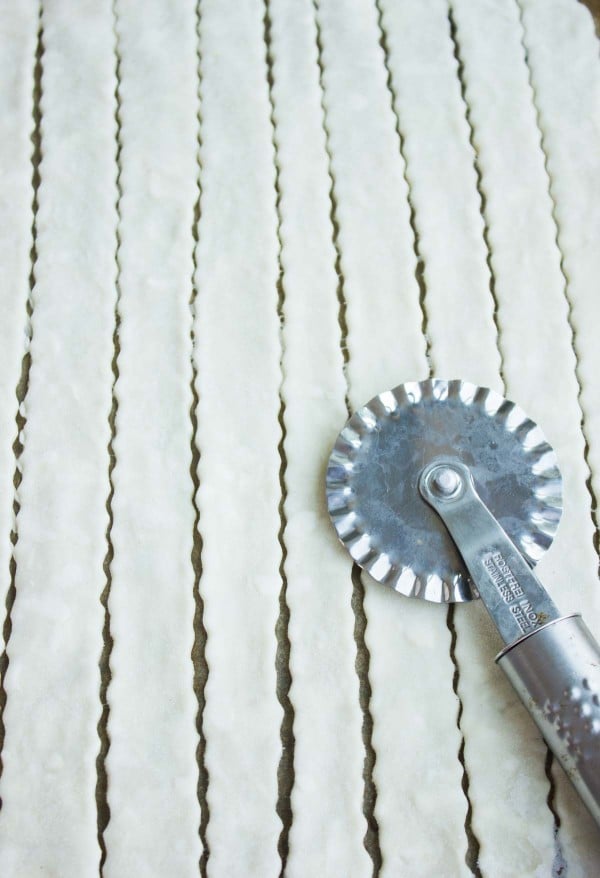 unbaked pie crust being cut into strips