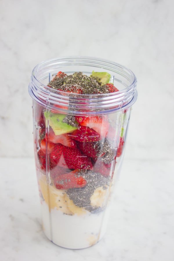 Ingredients for Banana Berry Avocado Chia Smoothie gathered in the bowl of a blender