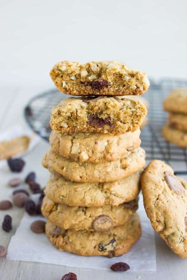 stacked Peanut Butter Chocolate Chip Cookies with the top cookie being broken in half to reveal the melted chocolate inside