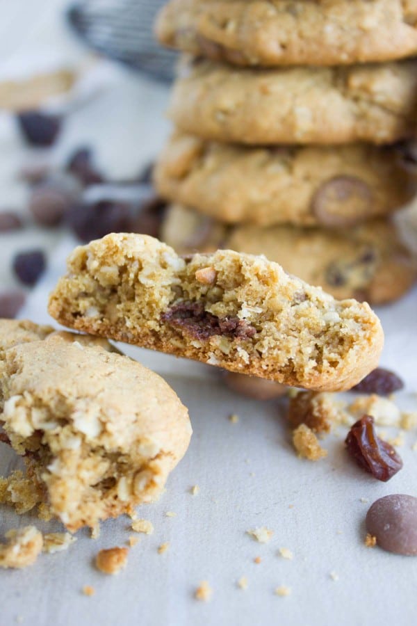 half of a Peanut Butter Chocolate Chip Cookie in front of a stack of chocolate chip cookies