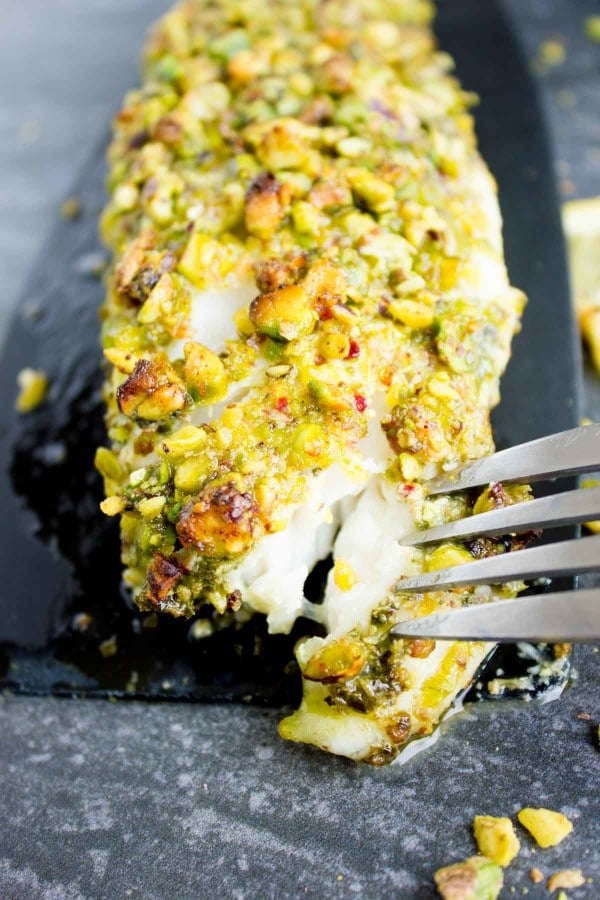 Close-up of Pesto Pistachio Fish Fillet with a fork taking a small bit out of the front.