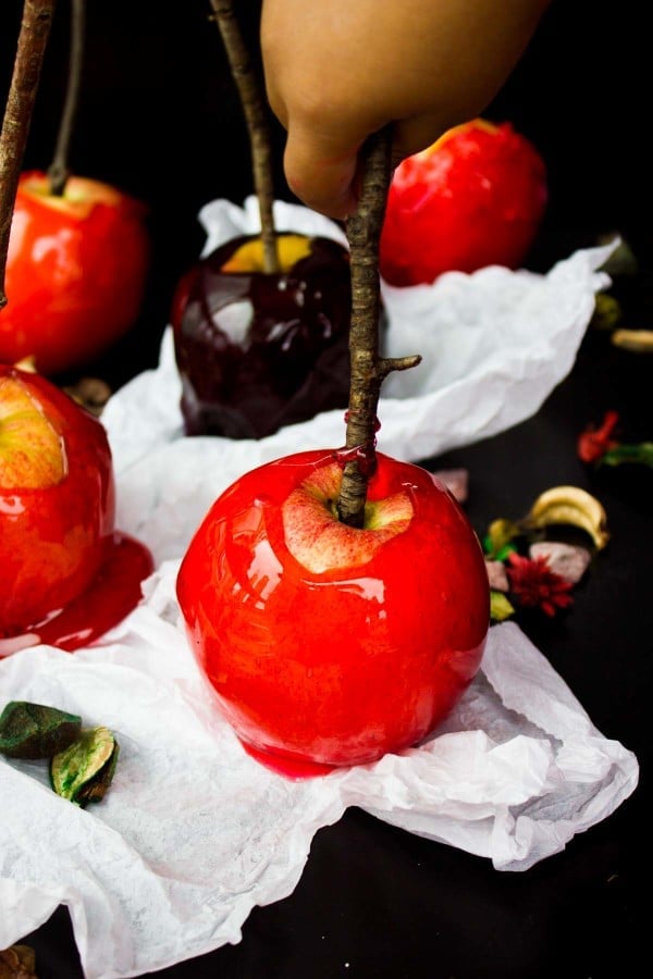 kids hands picking up rd candy apples