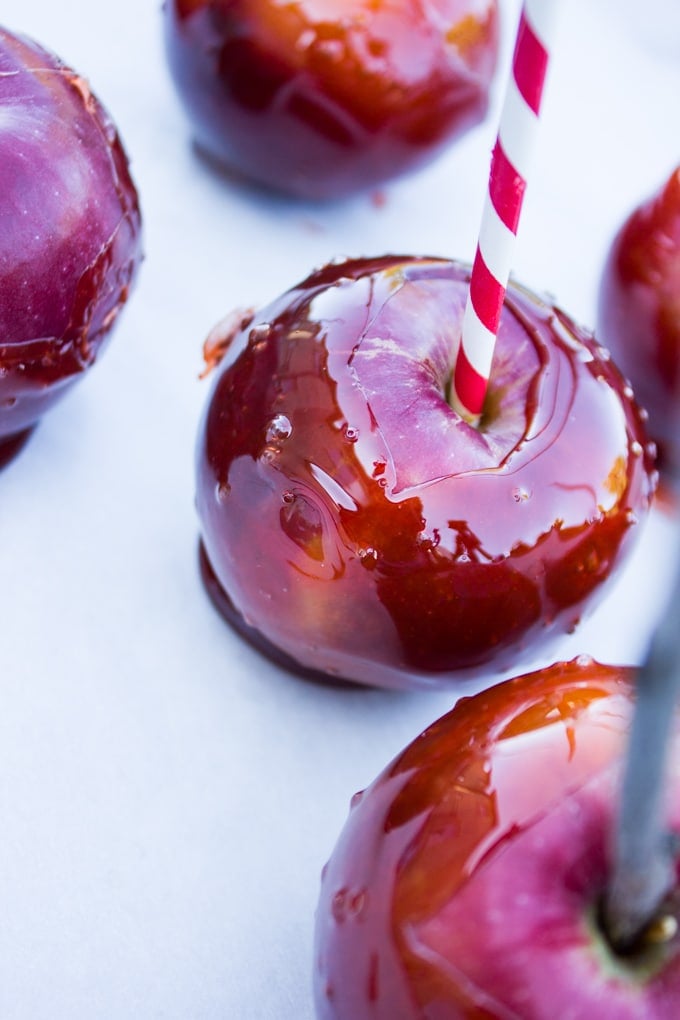 Candy apples dipped and ready to dry on parchment paper.