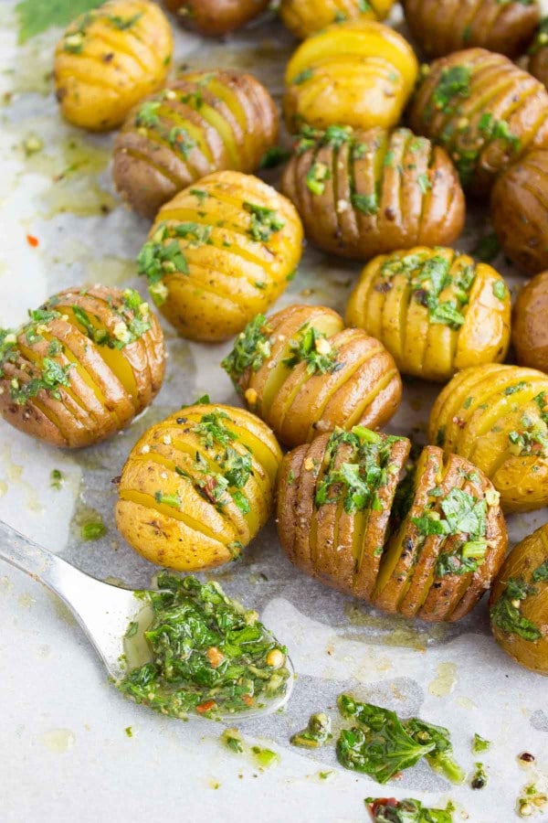 Best Herb Roast Potatoes arranged on a tray with a side of herb butter
