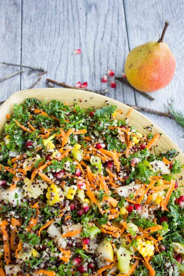 Quinoa Autumn Harvest Salad with grated carrot, quinoa and pomegranate seeds served in a wooden salad bowl